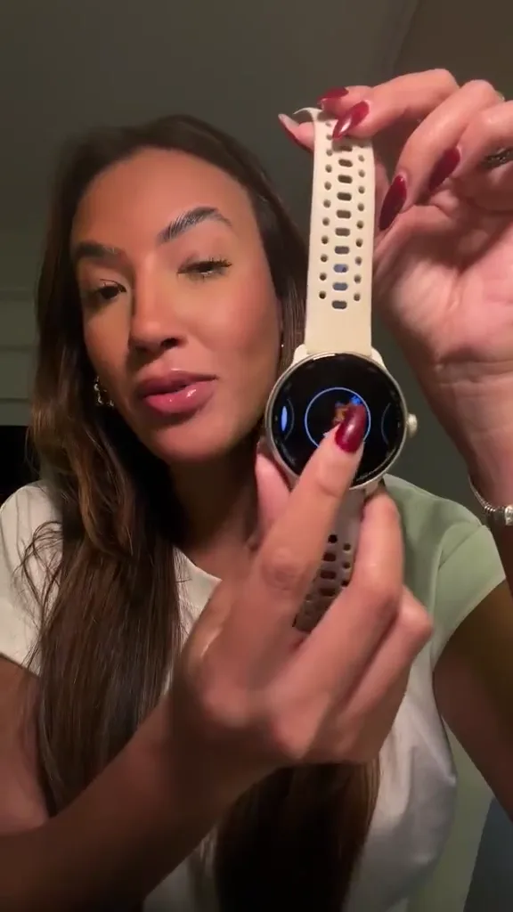 Mulher mostrando o relógio com pulseira clara